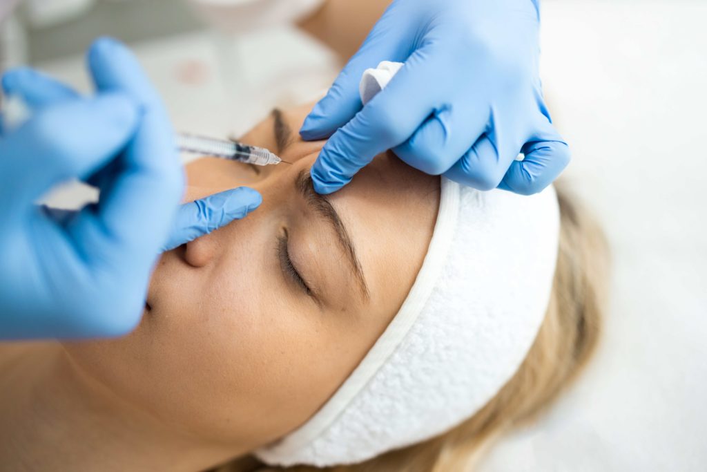 woman getting botox injections in between her eyebrows
